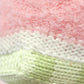 Close-up of the Baby Watermelon knitted fabric by Cuddle + Kind, featuring pink, white, and light green yarn with textured stitches and soft material—perfect for creating a handcrafted cotton toy or cherished soft baby companion.