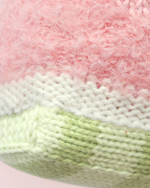 Close-up of the Baby Watermelon knitted fabric by Cuddle + Kind, featuring pink, white, and light green yarn with textured stitches and soft material—perfect for creating a handcrafted cotton toy or cherished soft baby companion.