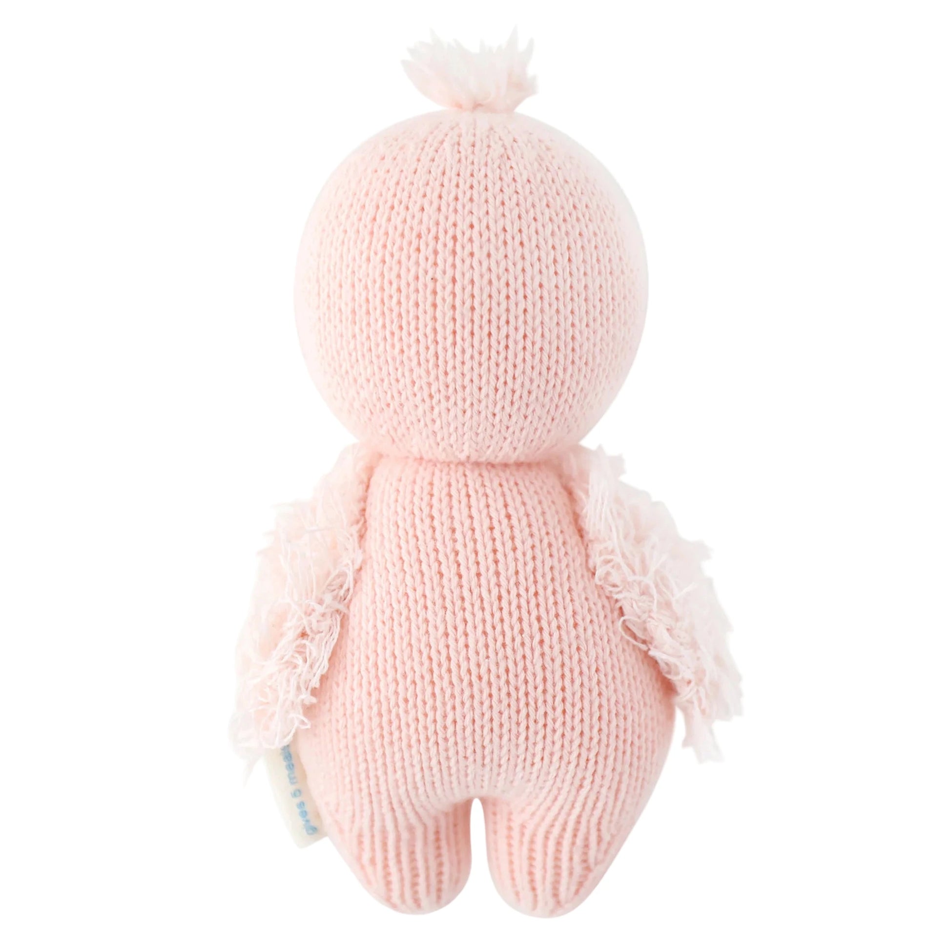 Cuddle + Kind’s Baby Flamingo is a pink, heirloom-quality plush doll with short arms, a round head, and a small tuft. Handcrafted from soft Peruvian cotton yarn, it offers lasting charm and sweet cuddles. Shown here from the back.