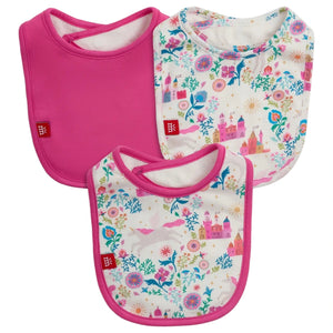 The Magnetic Me Tail of Magic Modal Bib 3-Pack includes three absorbent bibs: one solid pink and two with pink edges featuring unicorn, floral, and castle patterns on a white background.