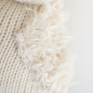 Close-up of Baby Gosling by Cuddle + Kind, featuring cream-colored Peruvian cotton yarn with textured, frayed details along the seam.