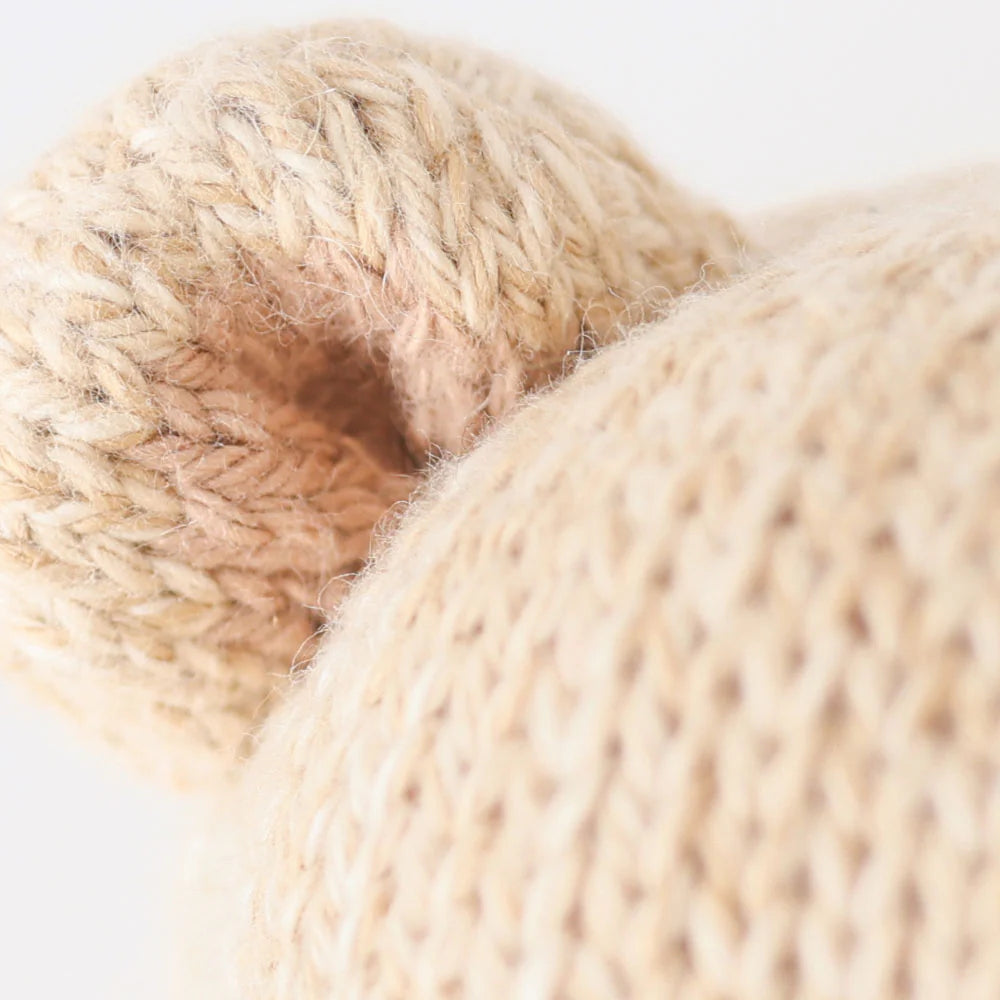 Close-up of Baby Honey Bear’s beige ear and head by Cuddle + Kind, hand-knit from soft Peruvian cotton yarn with detailed, heirloom-quality texture.