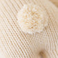 Close-up of Cuddle + Kind's Baby Rabbit - Oatmeal: heirloom-quality cream knit fabric with a matching yarn pom-pom—ideal for handcrafting dolls or baby animals.
