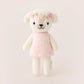 Tiny Charlotte the Dog by Cuddle + Kind is a hand-knit plush from the Tiny Collection, dressed in a pink dress and flower crown, shown standing upright against a simple light background. Perfect for collectors and snuggles.