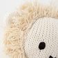 Close-up of Cuddle + Kind’s Baby Lion, an heirloom-quality, hand-knit plush with cream yarn, black eyes, and a textured thread mane—perfect as a cherished collectible.