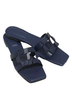 Introducing the Simkhai Monogram Flat Slide: a pair of midnight navy blue sandals featuring square toes and an elegant interlocking strap design.