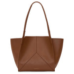 The Victoria Tote by Victoria Beckham is a brown leather bag with long shoulder straps and subtle stitching, Italian crafted and suede lined, shown against a white background.