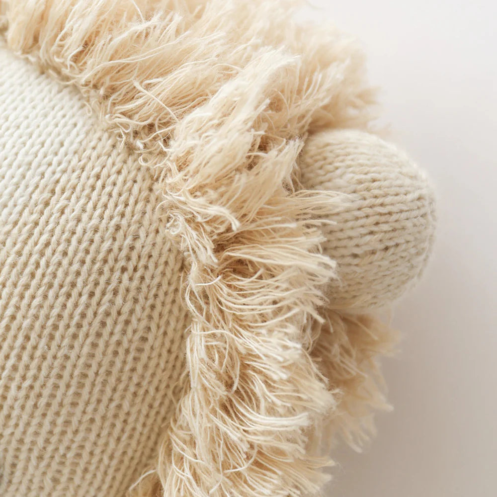 Close-up of Sawyer the Lion - Regular 20" by Cuddle + Kind, showing its knitted fabric, fringe mane, and rounded ear—an adorable detail that makes this plush toy a perfect heartfelt birthday gift.