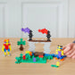 Plus Plus Tube - 240 Piece Basic Mix features colorful interlocking blocks for building figures, a tree, and a bridge on a wooden surface, fostering creative play and fine motor skills as kids adjust their creations.