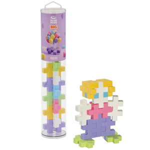 The Plus Plus Tube - BIG 15 Piece - Pastel is shown beside a colorful figure built from its interlocking blocks, offering creative STEM play and helping kids build fine motor skills.