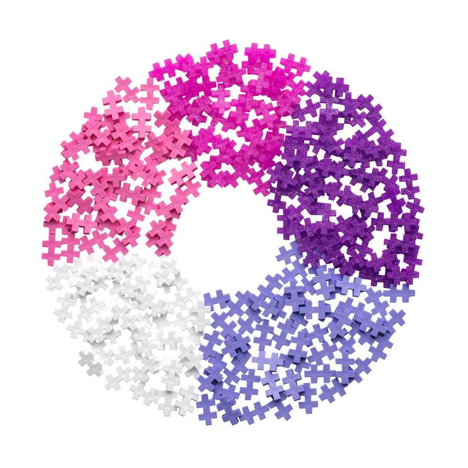 Plus Plus Tube - 240 Piece - Glitter Mix features colorful pieces—pink, purple, lavender, and white—arranged in a circular pattern on a white background, inspiring creative play and fine motor skill building.