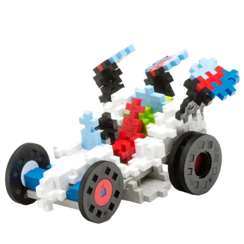 The Plus Plus Learn to Build - Vehicles set features interlocking blocks in white, blue, red, green, and black to create a race car with black wheels—a creative and fun construction toy for imaginative play.