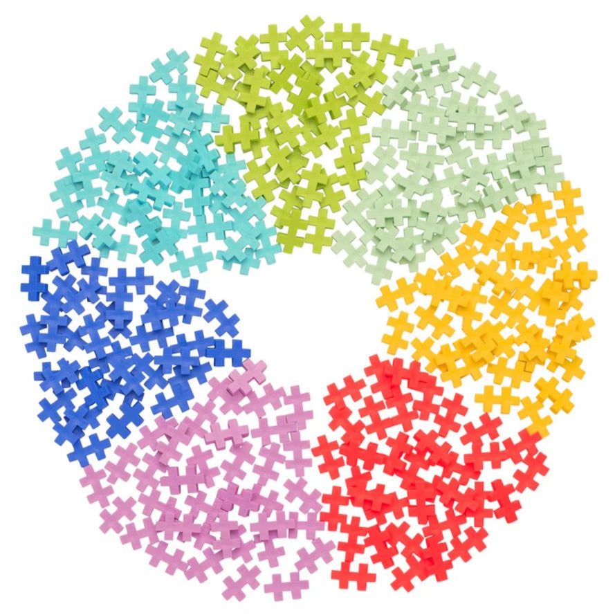The Plus Plus Tube - 240 Piece Tropical Mix features colorful interlocking pieces arranged in a circle around a white center, creating a vibrant STEM toy that inspires creativity and builds fine motor skills.