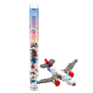 A Plus Plus Tube - Airplane stands beside a finished model, displaying its colorful white, gray, red, and blue blocks. This STEM toy inspires creativity and imaginative play.
