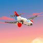 The Plus-Plus Tube - Airplane features interlocking blocks in white, gray, red, and blue, shown flying against a vibrant sunset sky—sparking creativity and imaginative STEM play for kids.