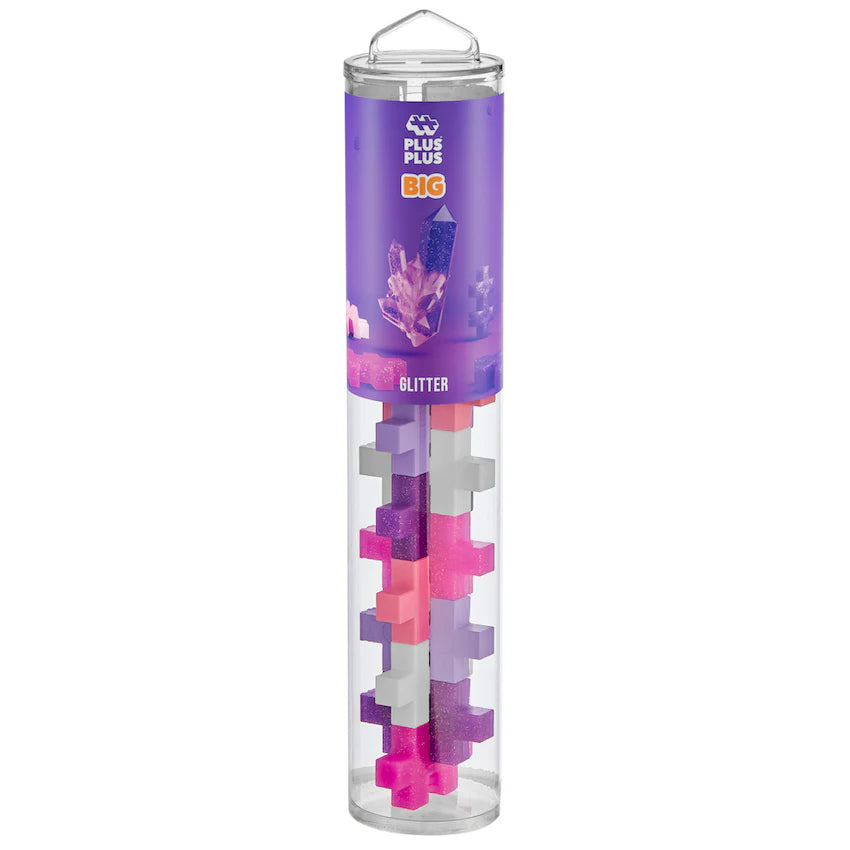 The Plus Plus BIG 15 Piece Tube - Glitter features pink, purple, white, and glitter BIG blocks in a clear cylinder with a purple label—ideal for creative 3D builds or expanding your Plus Plus collection.