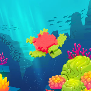 The Plus Plus Tube - Tangerine Turtle features interlocking blocks to build a sea turtle, inspiring fine motor skills and creativity in an underwater-themed play scene.
