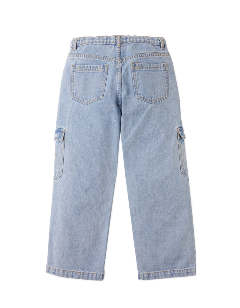 The Boys' Loose Cargo Pant Denim with Banana Print by Gingersnaps is displayed from the back, showcasing two rear pockets, banana-print pocket details, and side cargo pockets on each leg against a plain white background.