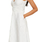 A woman wearing the Eliza Dress by Brandon Maxwell, a sleeveless white midi dress with a v-neckline and textured pattern, crafted from an Italian silk blend—an essential for the resort season.