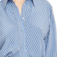 Close-up of a person wearing the Vera Shirtdress by Brandon Maxwell, showcasing a blue and white striped pattern with tailored diagonal stripes and a refined collar.