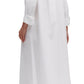 A person is wearing the TWP Jennys Gown with Crystal Collar, crafted from Italian cotton shirting, paired with black sandals and standing sideways.