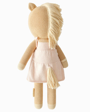 Kelsie the Pony by Cuddle + Kind—a regular 20" knitted horse plush toy with a cream mane and tail, dressed in a pale pink dress and shown from the back against a plain background—is perfect inspiration for creating a beautiful birthday gift.