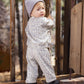 A toddler wearing the Rylee & Cru Baby Girls’ and Girls’ Oversized Sweatshirt stands on a wooden deck, looking back over their shoulder.
