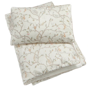 The Animal Parade Ivory Toddler Duvet by Gooselings adds a cozy touch to any kid's bed with its nature-themed print featuring branches, birds, and wildlife on a light background.