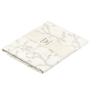 Wrapped in a white paper band adorned with text, the Animal Parade Ivory Swaddle by Gooselings features a beige and light gray floral pattern. Made of 100% cotton, this cozy swaddle adds charm to any nursery.