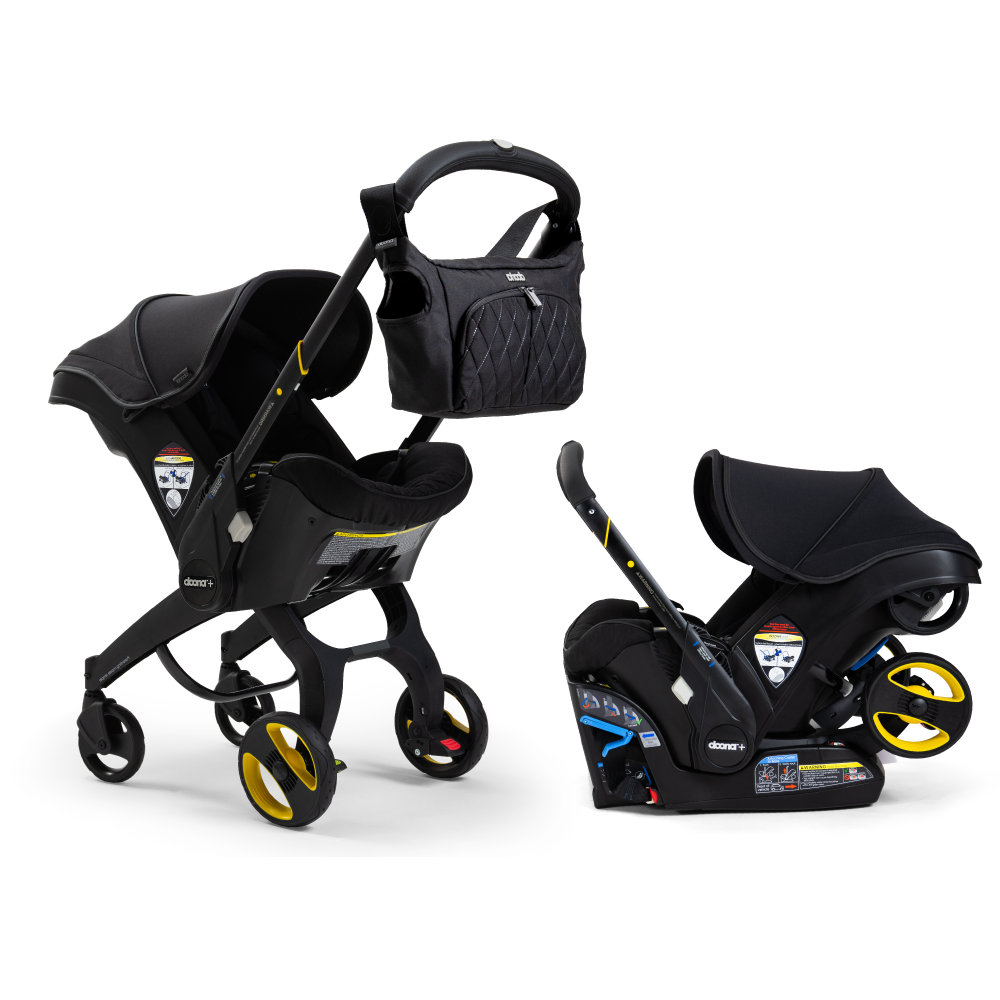 A Doona Car Seat and Stroller from the Midnight Edition, featuring a black design with yellow accents, is shown with a matching detachable infant car seat. A black quilted diaper bag is attached to the stroller handle.