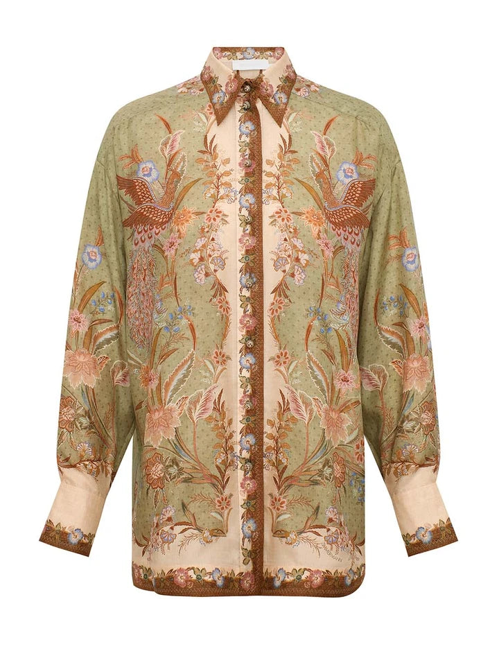 The Indra Relaxed Shirt by Zimmermann is a long-sleeved silk shirt with a green and beige base, earthy floral-bird print, and patterned collar and cuffs.