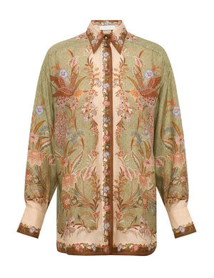 The Indra Relaxed Shirt by Zimmermann is a long-sleeved silk shirt with a green and beige base, earthy floral-bird print, and patterned collar and cuffs.