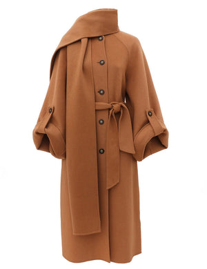The Valiant Wool Scarf Coat by Zimmermann is a camel design with large buttons, a matching belt, wide sleeves, and a scarf draped at the collar.