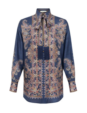 The Valiant Relaxed Shirt by Zimmermann features long sleeves, a navy paisley base with floral patterns, and a matching tassel necktie.