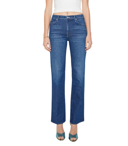 A person stands against a white background wearing Mother’s Kick It high-rise straight-leg jeans—crafted from recycled stretch denim with a 32-inch inseam—paired with a white cropped top and teal open-toed heels. Their hands rest relaxed at their sides, highlighting the jeans’ fit and length.