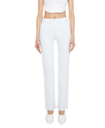 A person is wearing the Mother Kick It high-rise straight-leg jeans in a light blue wash, styled with a white crop top and white pointed shoes, standing facing forward against a plain background.