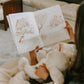 On a couch, someone holds an open "Bun Bun - A Lovey Story" book from Bunnies By the Bay, while a child snuggles beside them clutching their Bun Bun plush toy.