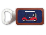 The Smathers & Branson Golf Cart Bottle Opener features a needlepoint design of a red golf cart carrying a person and a golf bag on a navy background, framed by a chestnut wood handle with hidden magnets.