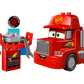 The LEGO® DUPLO® Mack at the Race by Legos - Toyhouse is a red truck with cartoon eyes, “95” and “Rust-eze” decals, plus accessories like a toolbox, cone, engine, tire, and wrench—just like in the Disney Pixar Cars movie.