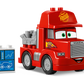 The LEGO® DUPLO® Mack at the Race by Legos - Toyhouse features a red "Mack" truck with cartoon eyes and "95", plus a blue and white car-themed block—great for young fans of LEGO DUPLO Cars sets!.