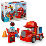 Inspired by LEGO® DUPLO® Mack at the Race from Legos - Toyhouse, this set for ages 2+ includes a red toy truck, toolbox with tools, tire, cones, and an illustrated box showing the assembled Mack truck.