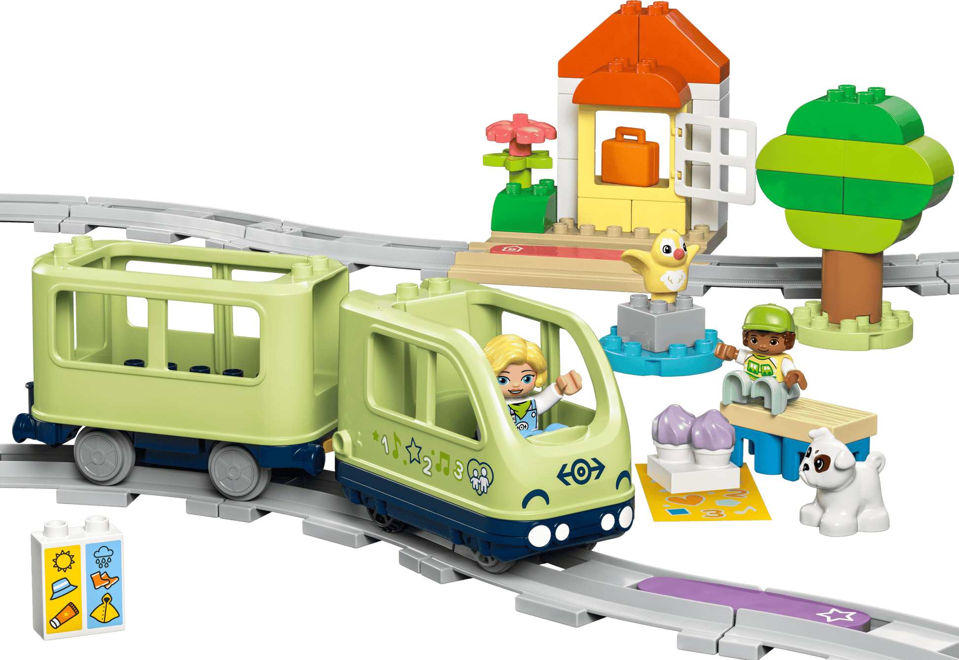 The LEGO® DUPLO® Interactive Adventure Train by Legos - Toyhouse includes two figures, a dog, a small house, trees, and colorful accessories on a curved gray track—an ideal train set for toddlers.