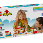 A child and adult enjoy building with the LEGO® DUPLO® Peppa Pig Supermarket by Legos - Toyhouse; the box features an age range, set name, and colorful blocks, making it perfect for preschoolers.
