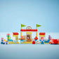 The LEGO® DUPLO® Peppa Pig Supermarket by Legos - Toyhouse features a building with flags, toy food items, small figures, a cart, and a red car—perfect for preschool kids.