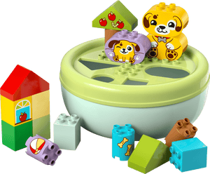 The LEGO® DUPLO® Shape Sorter: Puppy House by Legos - Toyhouse features colorful building blocks with animal faces and designs, arranged around a round shape sorter to encourage fine motor skills.