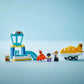 The Legos - Toyhouse LEGO® DUPLO® First Time at the Airport set features a yellow airplane, control tower, two minifigures, a brown animal figure, and small accessories—perfect for preschoolers.