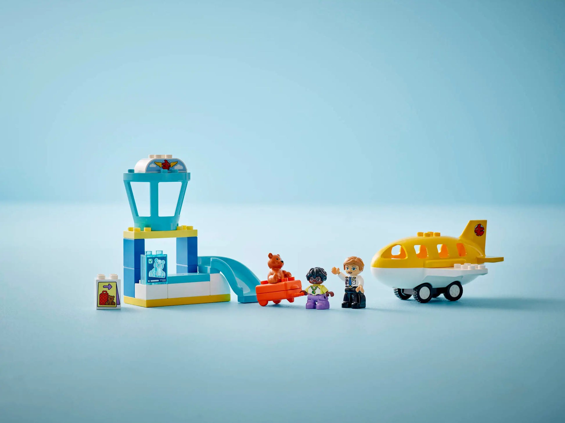 The Legos - Toyhouse LEGO® DUPLO® First Time at the Airport set features a yellow airplane, control tower, two minifigures, a brown animal figure, and small accessories—perfect for preschoolers.
