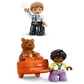 The LEGO® DUPLO® First Time at the Airport set by Legos - Toyhouse includes a police officer, a child figure, and an orange chest with a teddy bear—perfect as a preschool learning toy or building toy for imaginative play.