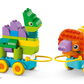 The LEGO® DUPLO® 3in1 Dinosaurs on Wheels by Legos - Toyhouse features two colorful, wheeled toy animals—a dinosaur and a lion—connected by yellow loops for fun toddler building and play.