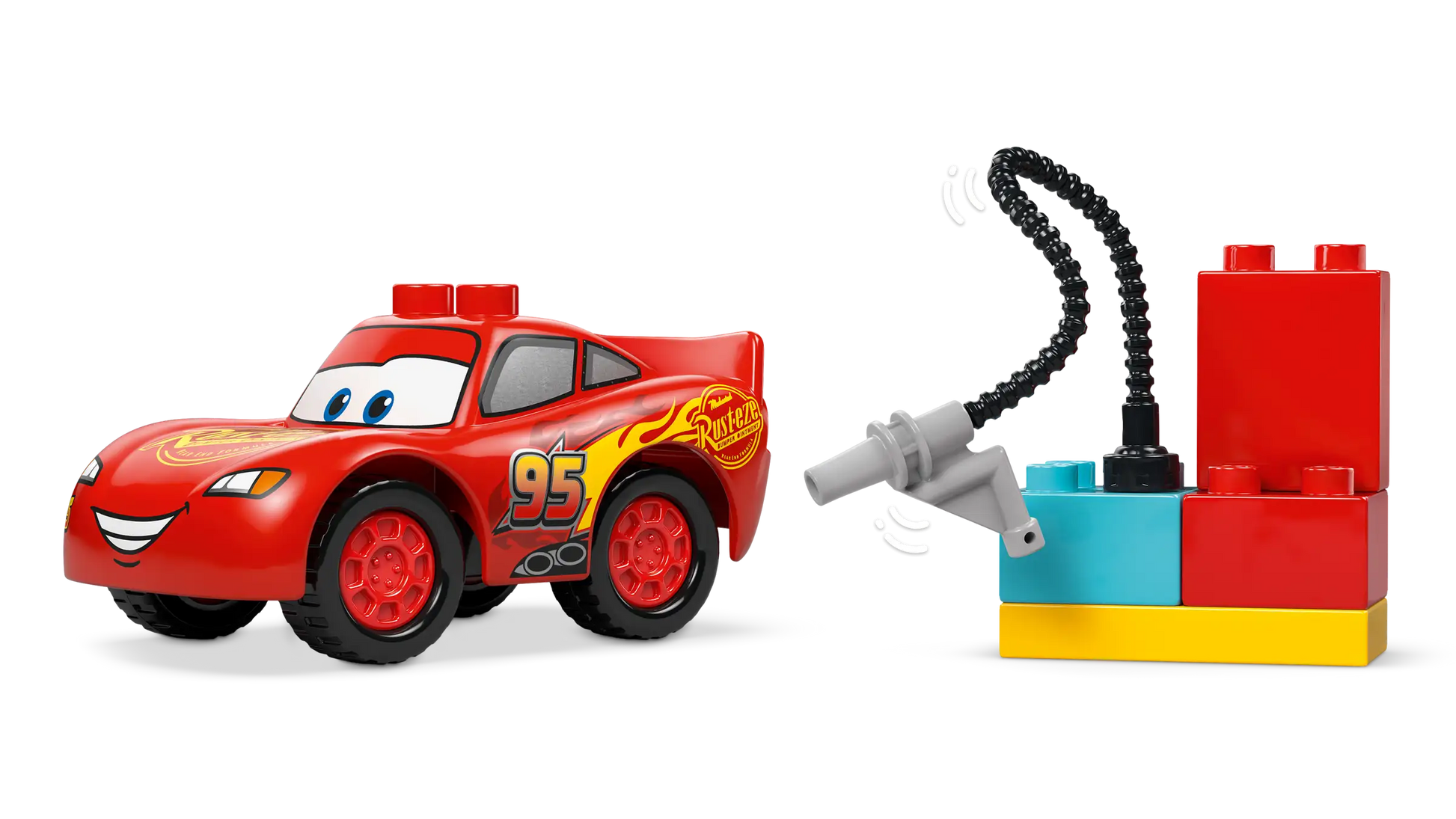The LEGO® DUPLO® McQueen's Visit to Doc's Garage by Legos - Toyhouse features a toy car with number 95 and a smiling face, plus red, blue, and yellow building blocks and accessories—great for any toddler playset.